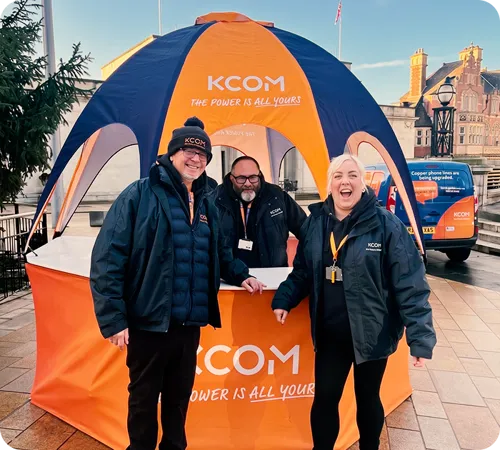 KCOM staff at a branded event tent promoting full fibre broadband, with a KCOM engineer van behind them