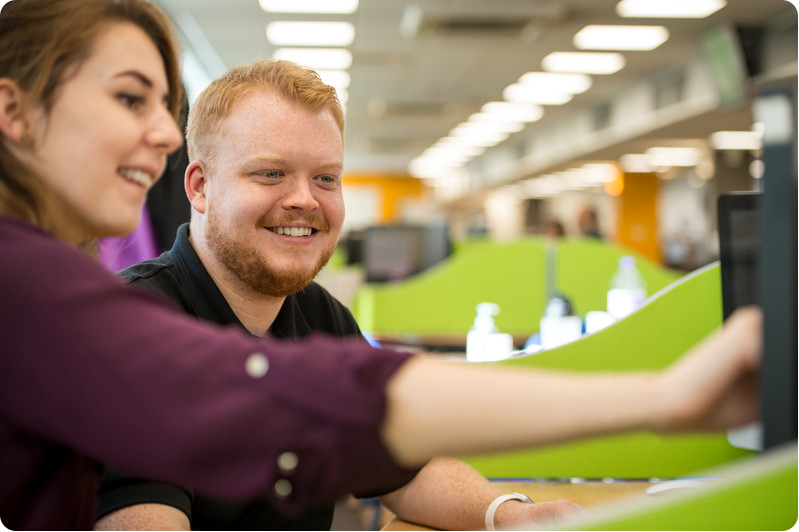 Two KCOM service desk employees happily working together