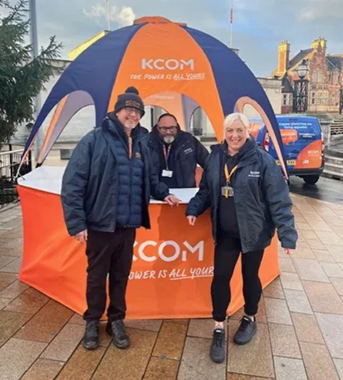 KCOM staff at a branded event tent promoting full fibre broadband, with a KCOM engineer van behind them