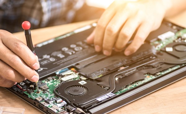 Close-up of person using tool to fix computer.