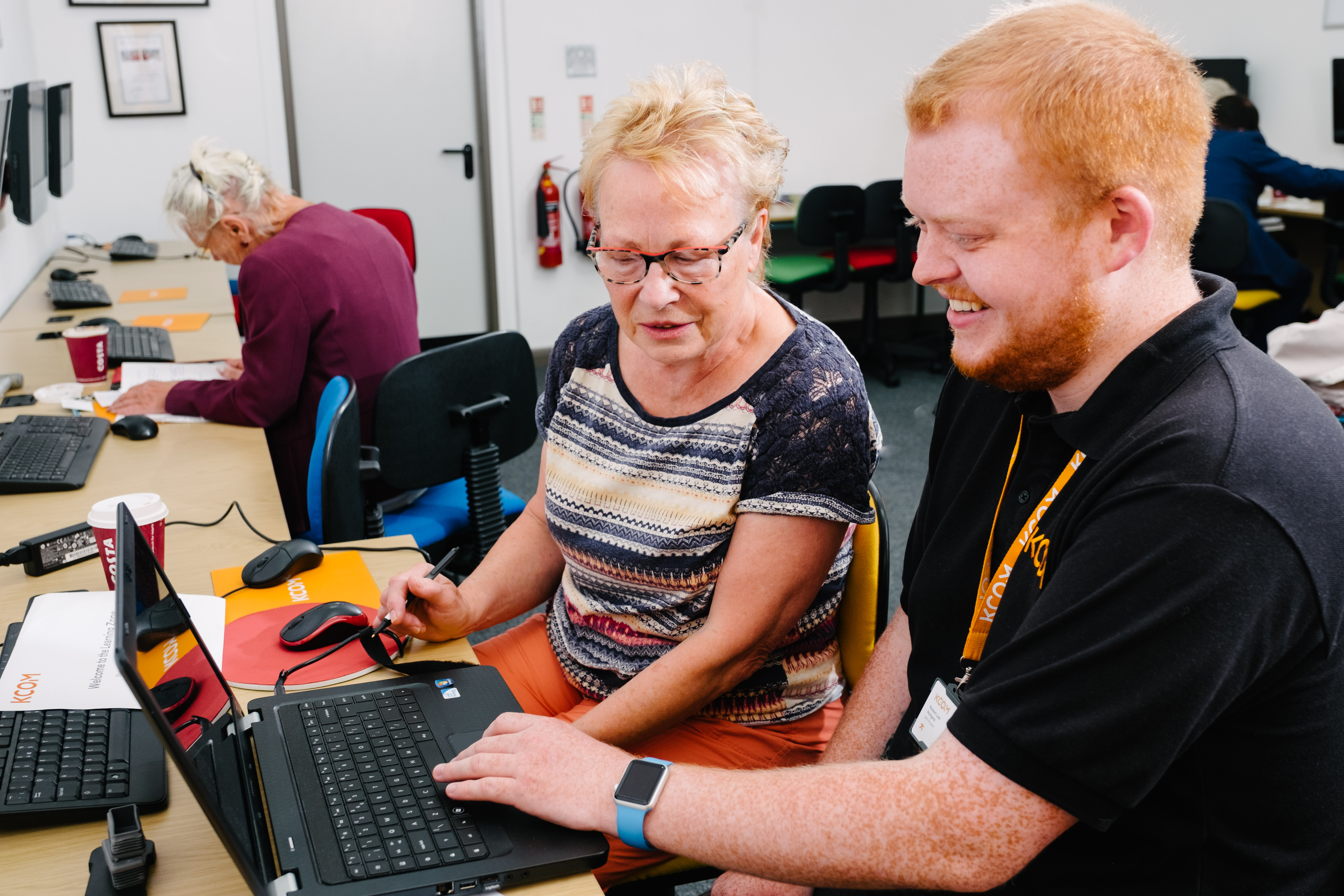 An advisor talking to a member of the public with a laptop