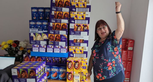 Woman celebrating next to lots of chocolate eggs