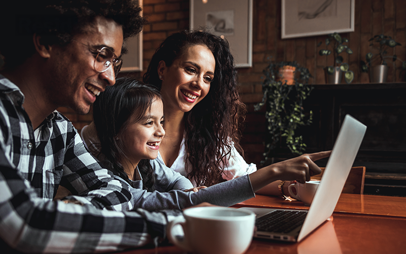 Family happily using laptop together